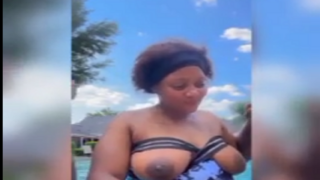 African lady having fun inside pool while naked